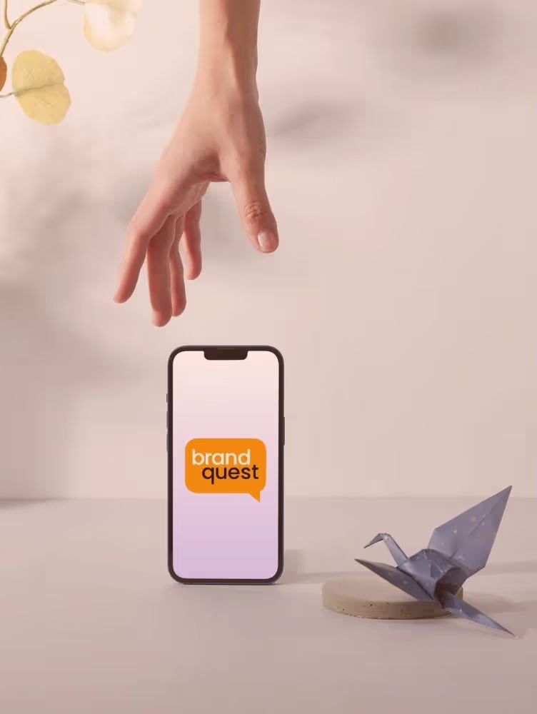 Hand reaching for the phone that has BrandQuest program on it. 